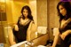 A woman in a black dress standing in front of a mirror.