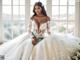 A woman in a wedding dress sitting in front of a window.