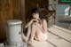 A woman sitting on the floor next to a heater.