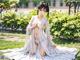 A woman in a white kimono sitting on the grass.