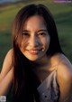 A woman with long brown hair smiles at the camera.