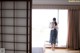 A woman standing in front of a window in a room.