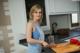 A woman standing in a kitchen preparing food on a cutting board.