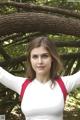 A woman in a white and red shirt posing for a picture.