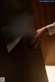 A woman's hand is touching the door handle of a hotel room.