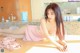 A woman in a pink lingerie laying on a table.